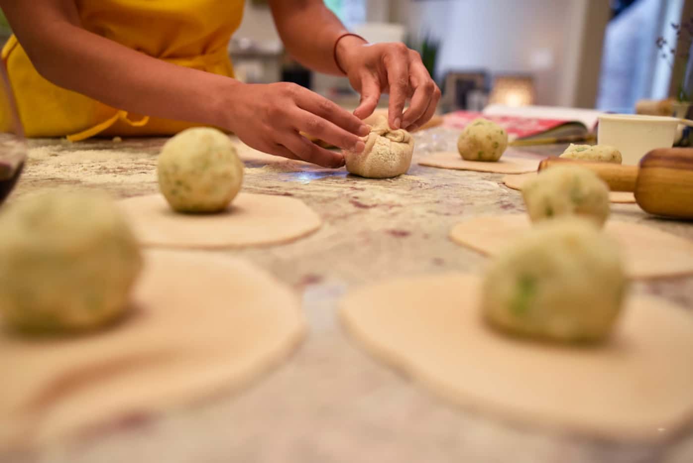 Food writer Priya Krishna rolls and folds dough while preparing paratha.