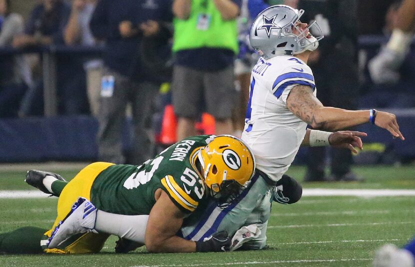 Dallas Cowboys quarterback Dak Prescott (4) gets the pass away but pays the price with a hit...