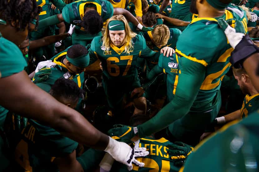 Baylor players, including long snapper Thor Rodoni (67) kneel in prayer after a victory over...