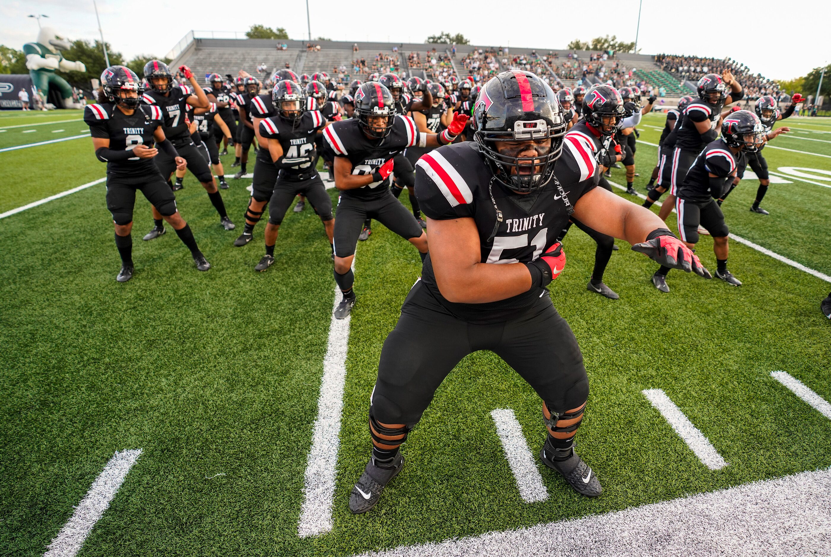 Euless Trinity offensive lineman Peni Masima (51) leads teammates as they do the Sipi Tau...