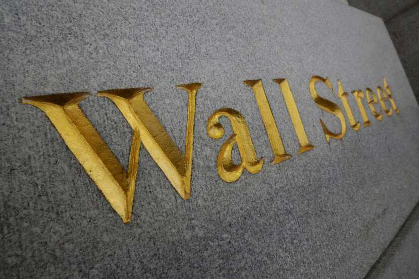 In this Oct. 2, 2014, file photo, Wall Street is etched in the facade of a building in New...