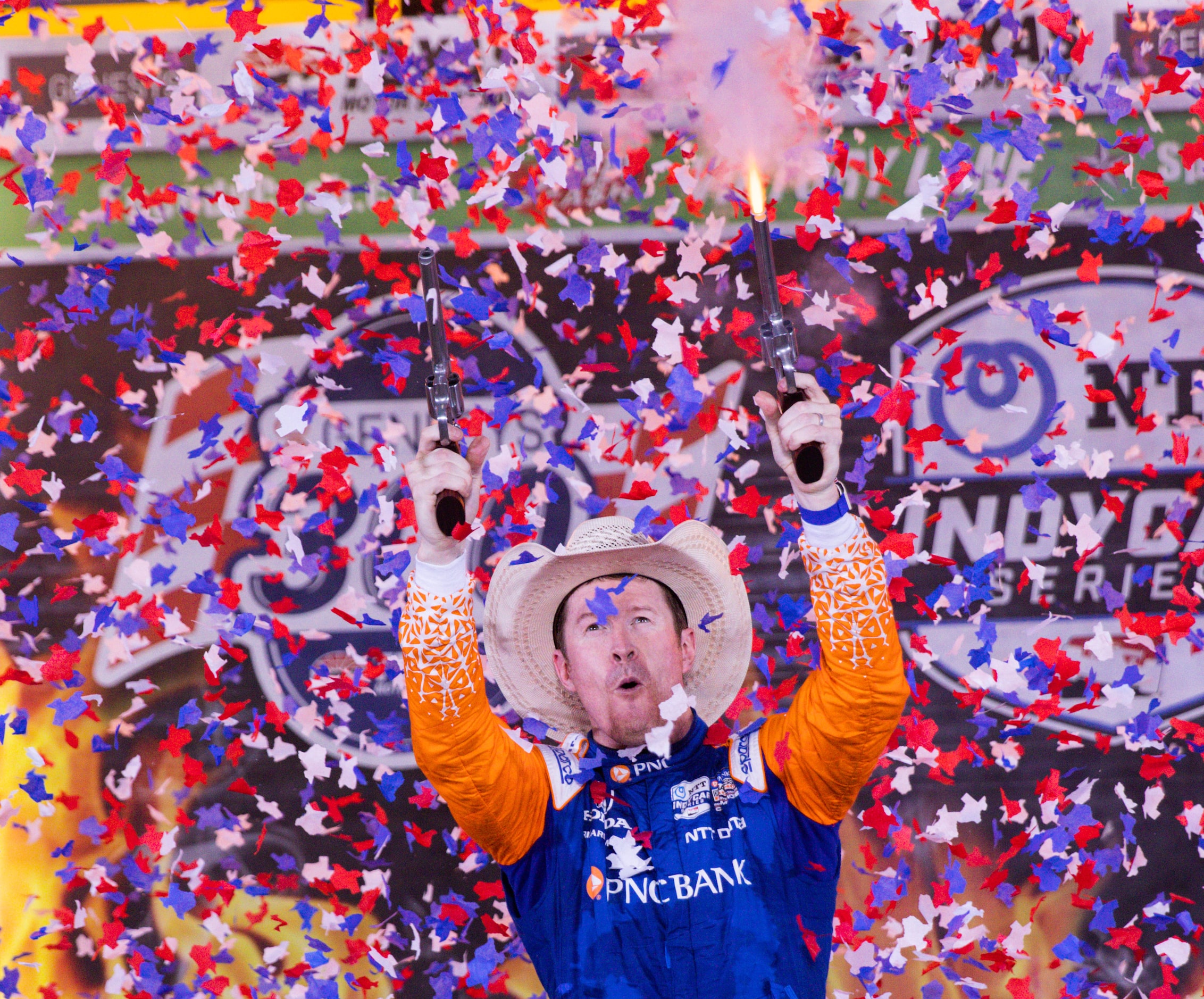 Scott Dixon (#9) celebrates in Victory Lane by firing the six-shooters after winning the...