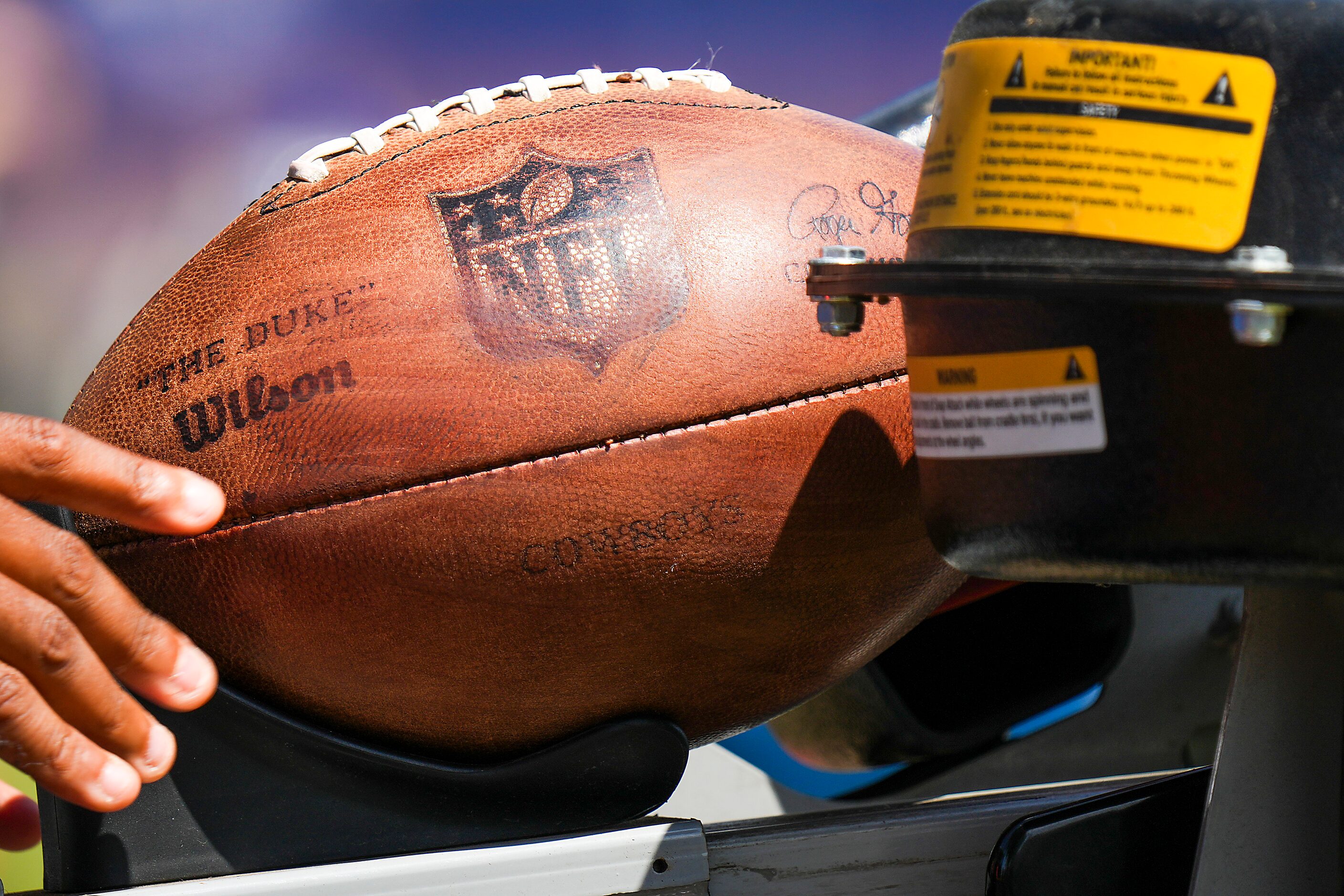 A ball is fed into a football throwing maching during a training camp practice on Friday,...