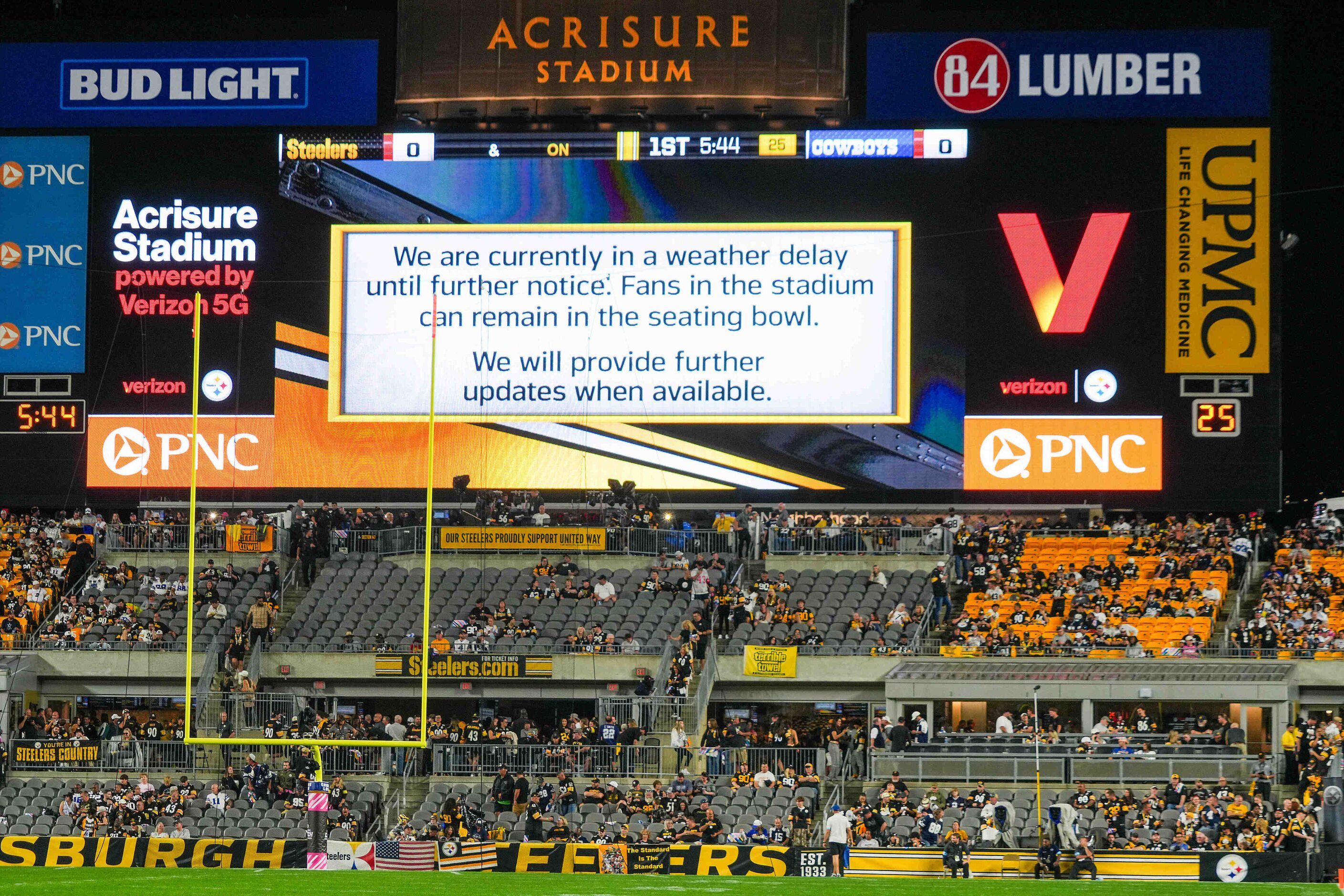 Messages on the scoreboards alert fans to a weather delay before an NFL football game...