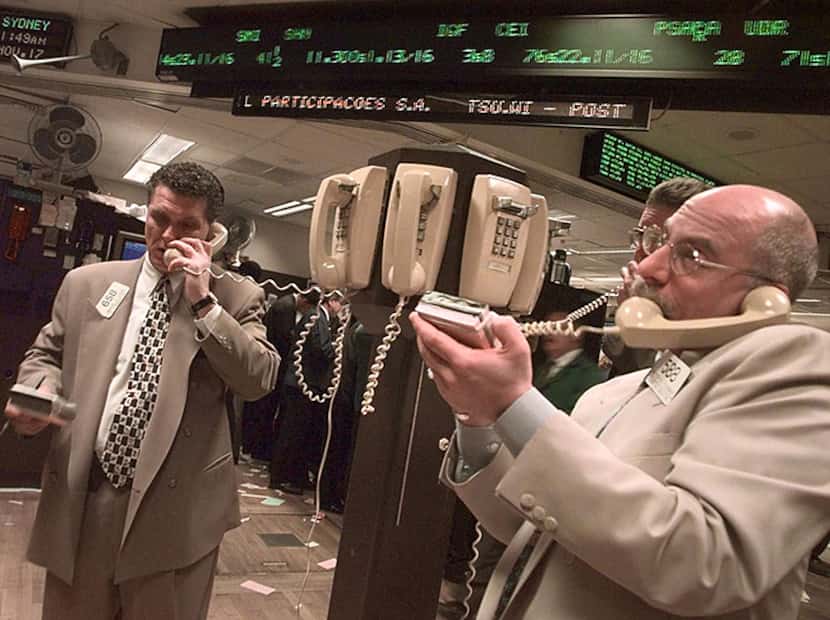  New York Stock Exchange trader Peter Tuchman, right, and others talk at a phone post,...