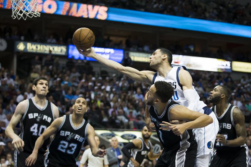Dallas Mavericks center Salah Mejri (50) reaches for a rebound over San Antonio Spurs...