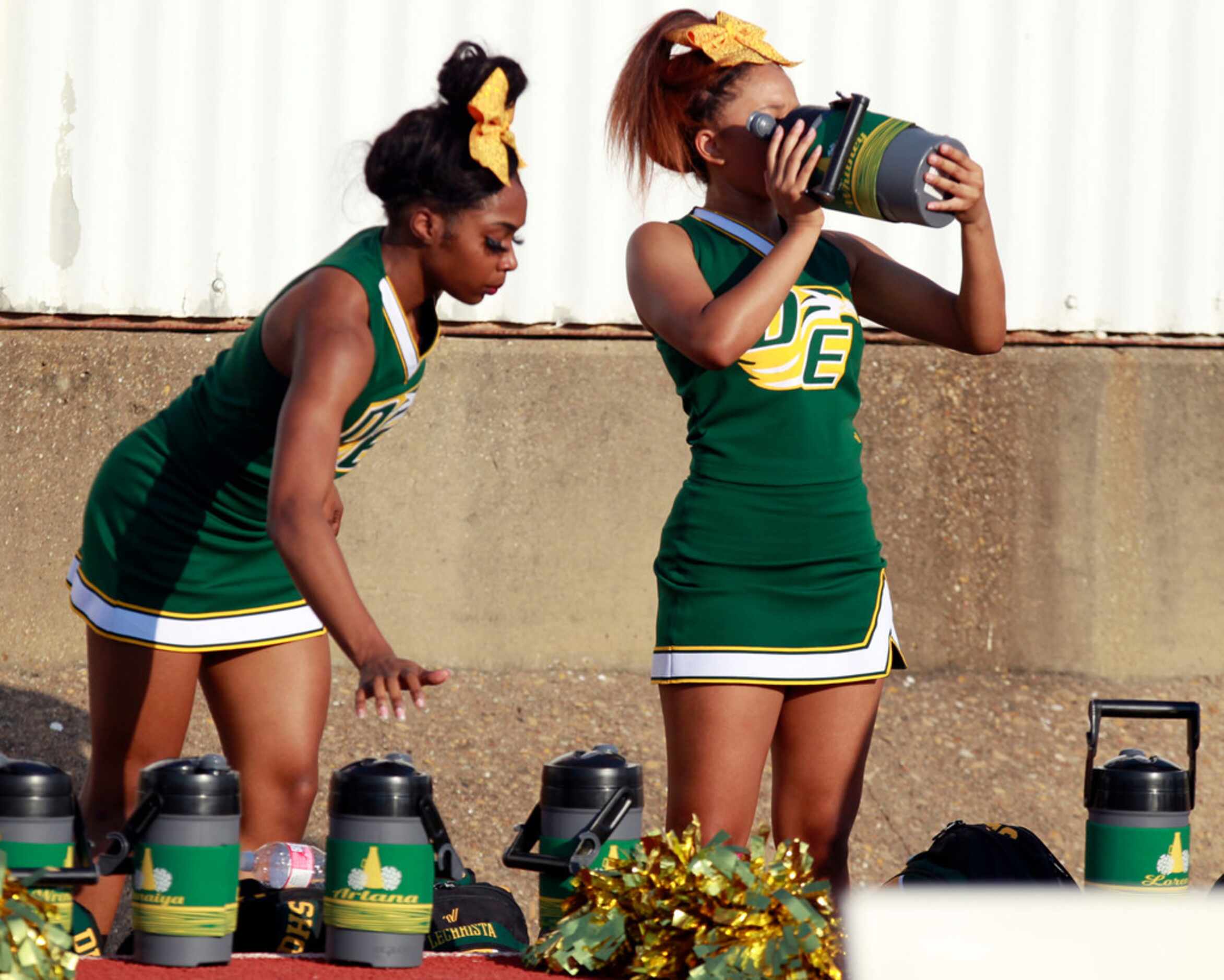 Desoto Cheerleaders drink water in the heat during the first half of the Bishop Dunne...