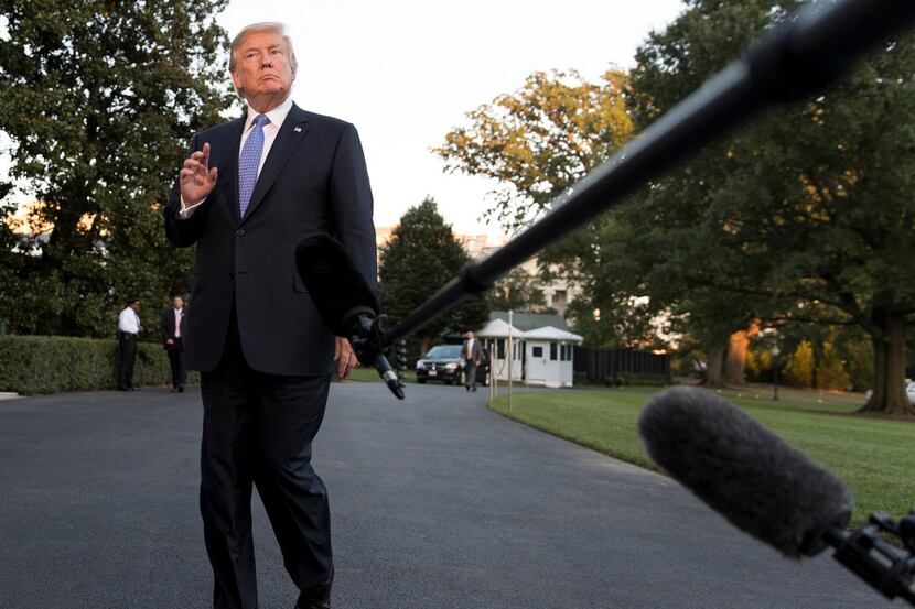 President Donald Trump looks to the media as he walks from Marine One to the White House in...