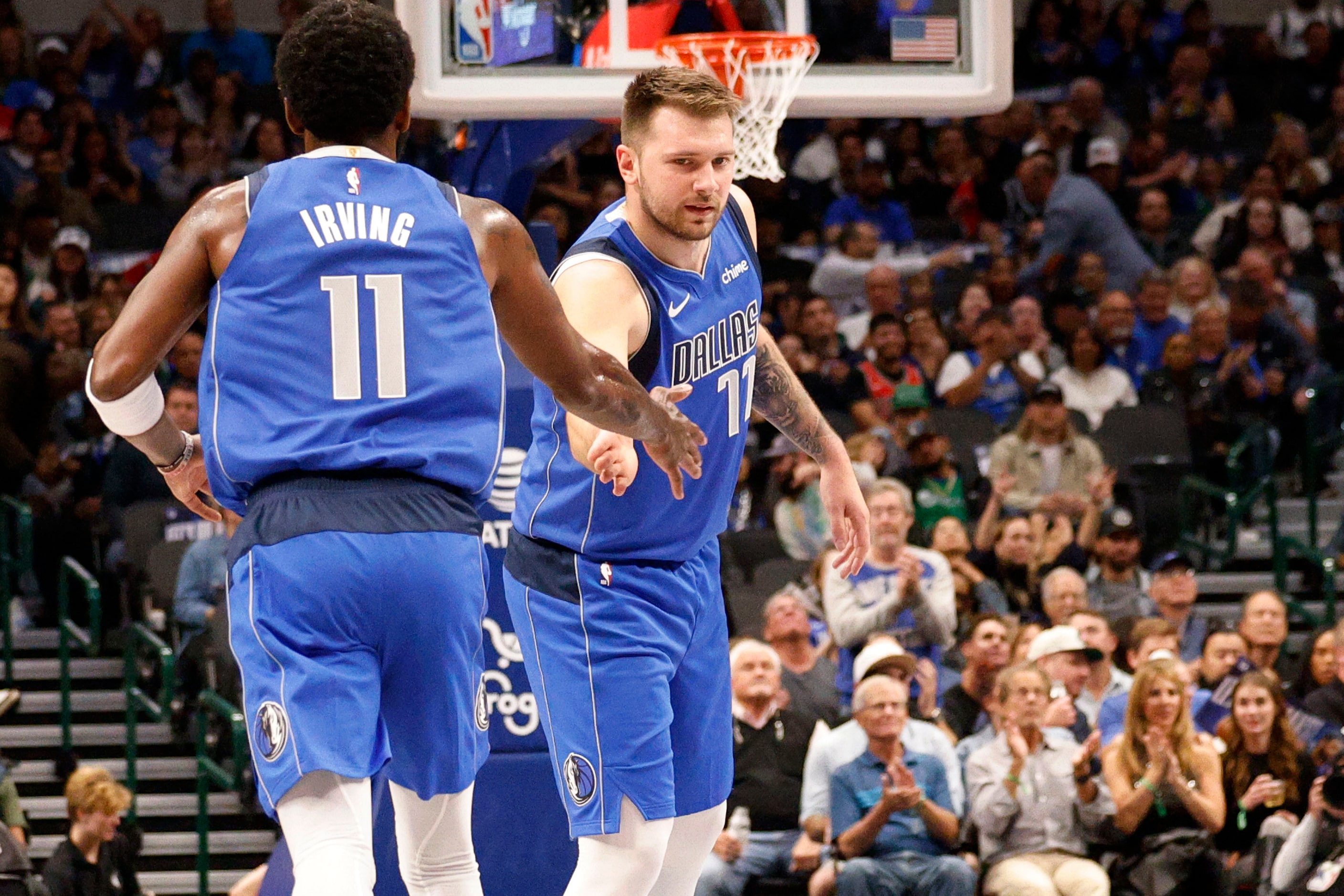 Dallas Mavericks guard Kyrie Irving (11) gets a high-five from his teammate Luka Doncic (77)...