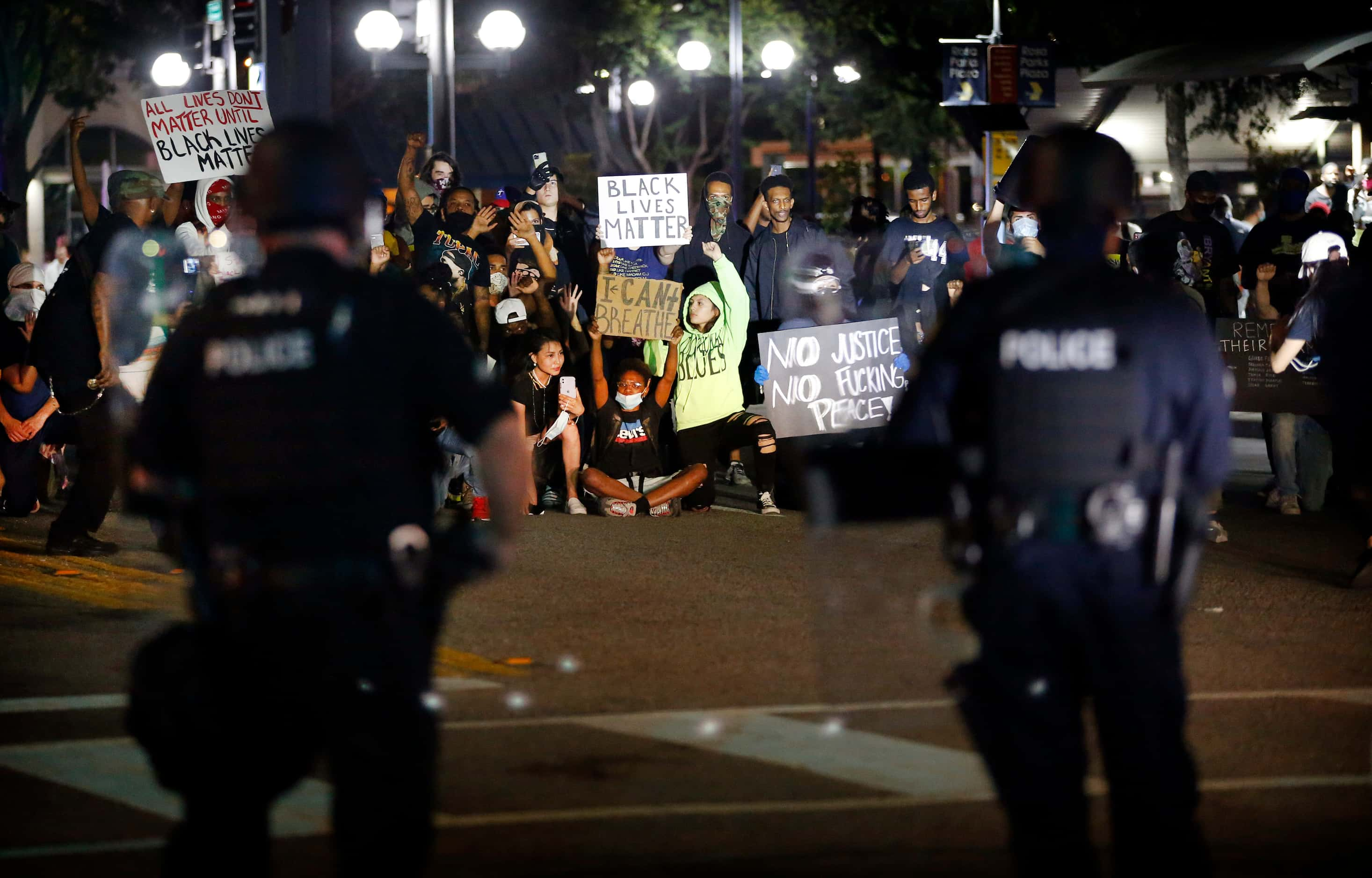 Protestors form a line blocking N. Lamar St before police fired pepper spray bullets and...