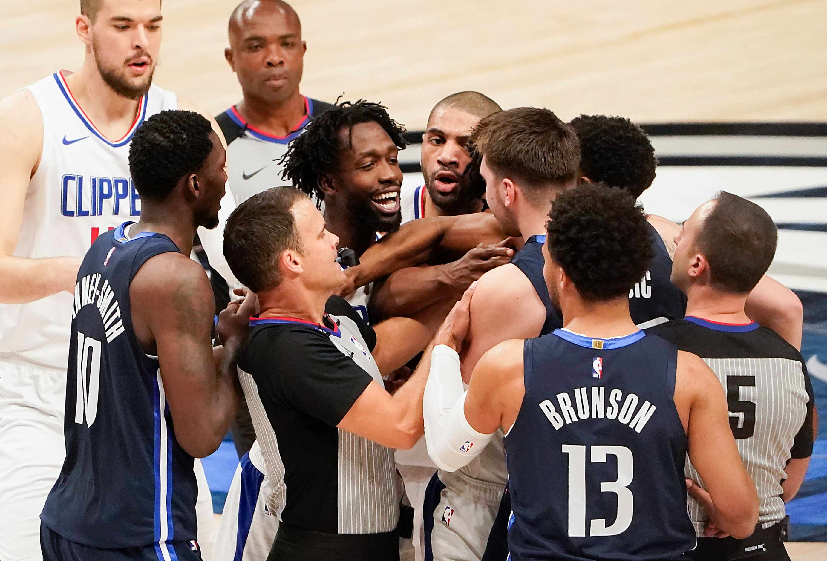 Officials and teammates rush in to separate Dallas Mavericks guard Luka Doncic (77) from LA...