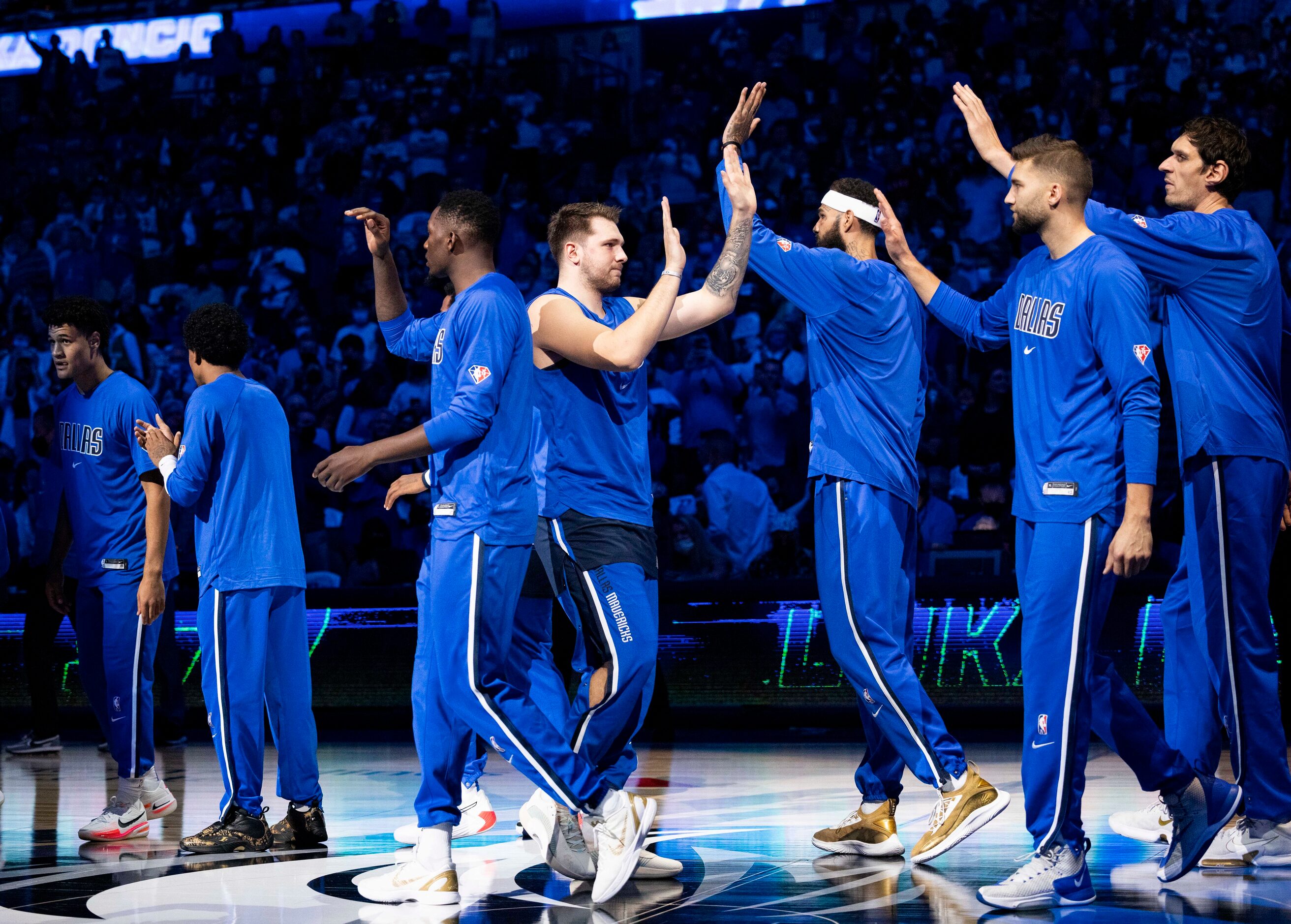 Dallas Mavericks guard Luka Dončić (77) highfives his teammates before the start of the...