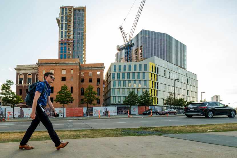 A pedestrian passes The Epic mixed-use development under construction in Deep Ellum. The...