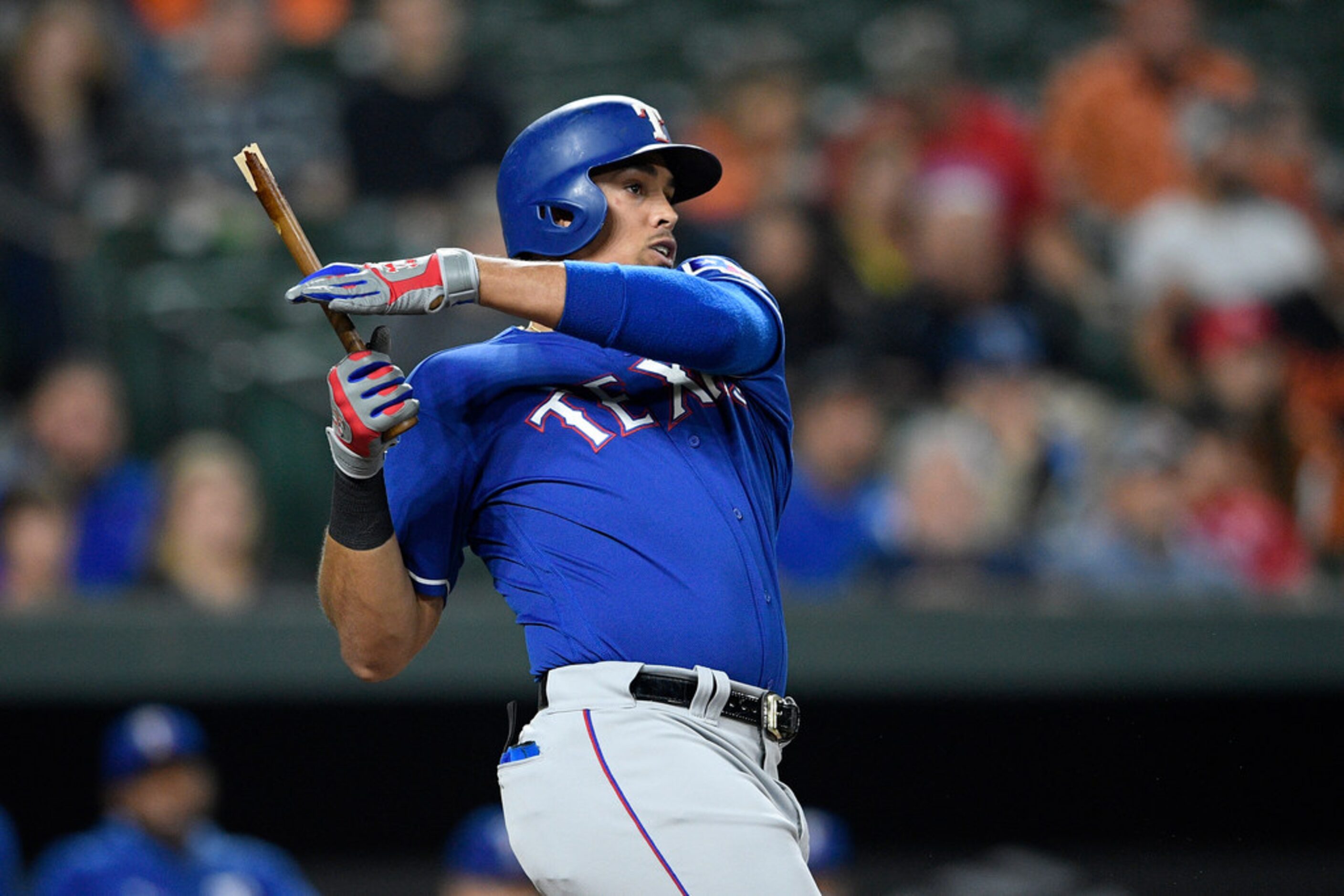 Texas Rangers' Ronald Guzman follows through on a broken-bat single during the fourth inning...