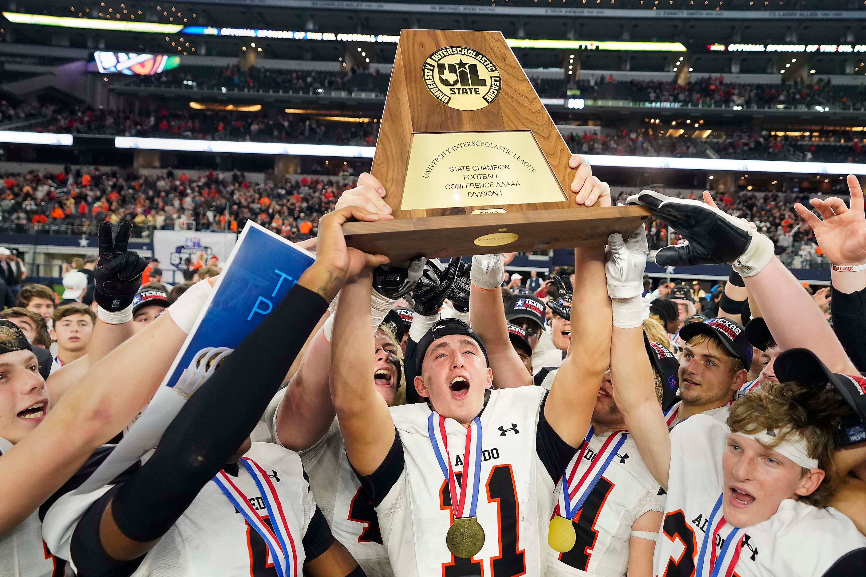 Aledo wide receiver Trace Clarkson (11) lifts the championship trophy after a victory over...