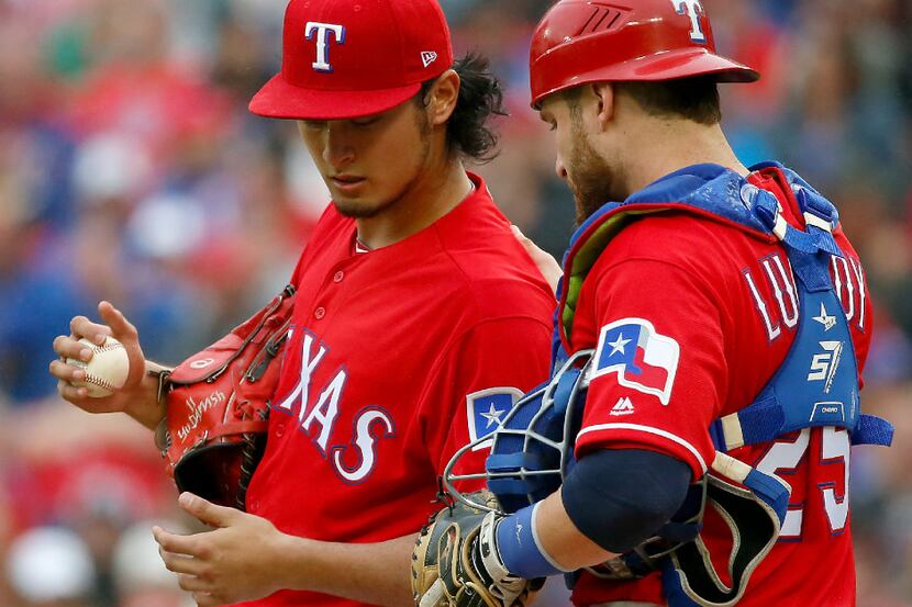 Texas Rangers starting pitcher Yu Darvish (11) talks with catcher Jonathan Lucroy during the...