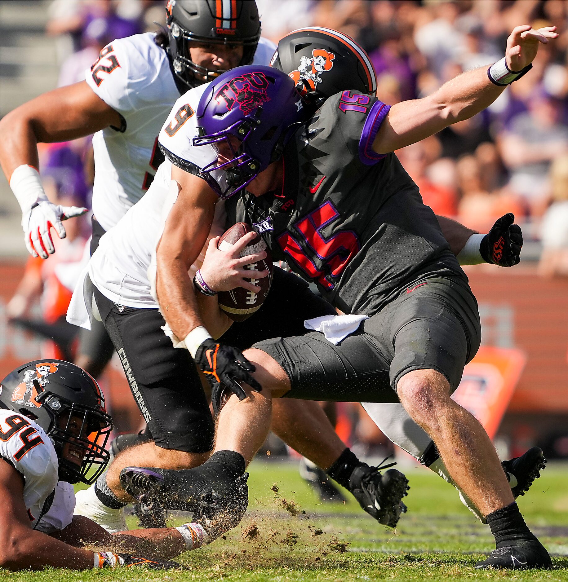 TCU quarterback Max Duggan (15) is dropped for a loss by Oklahoma State defensive end Brock...