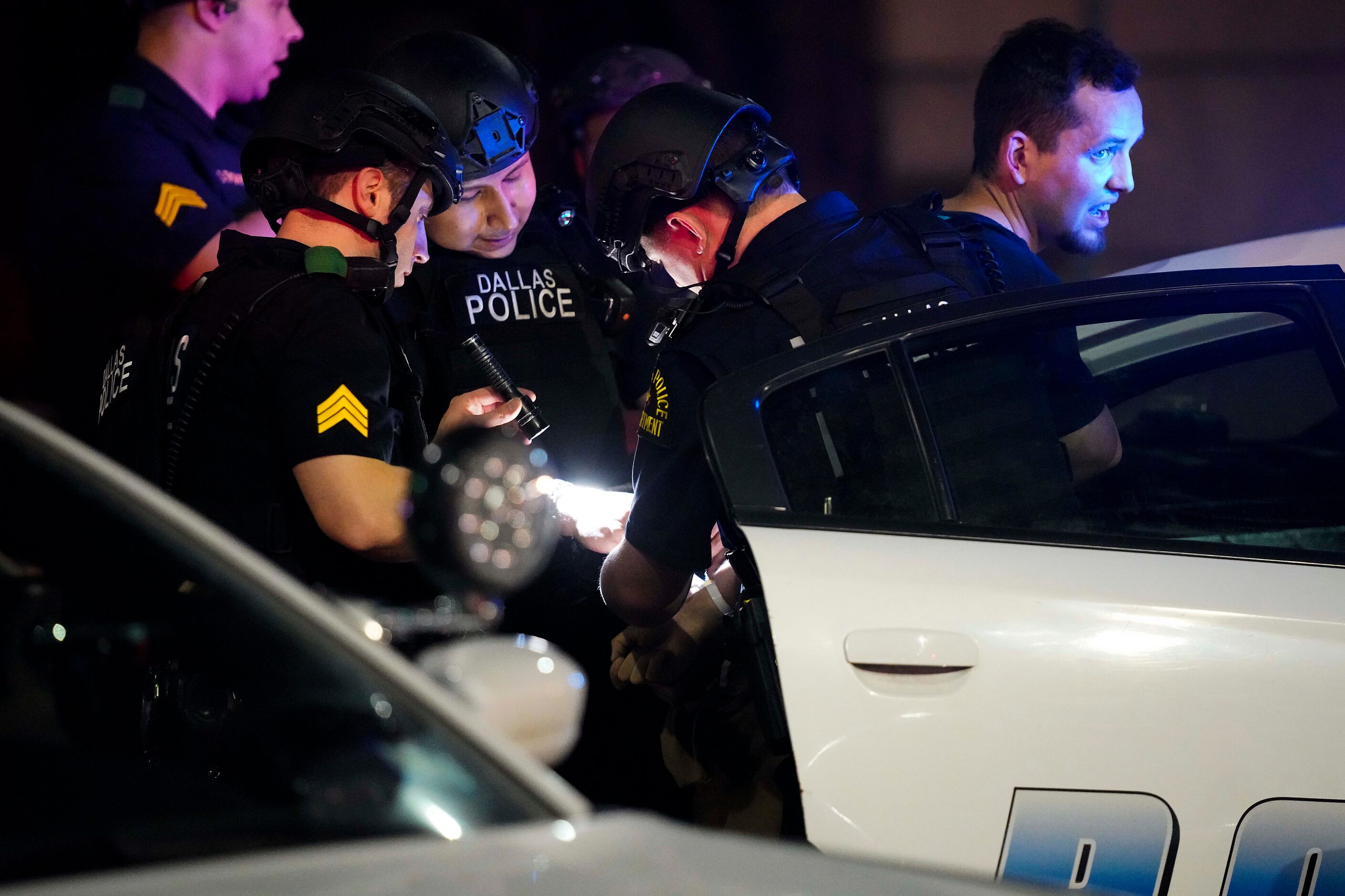 Dallas police arrest a man at Main Street and St. Paul as they go block by block working to...