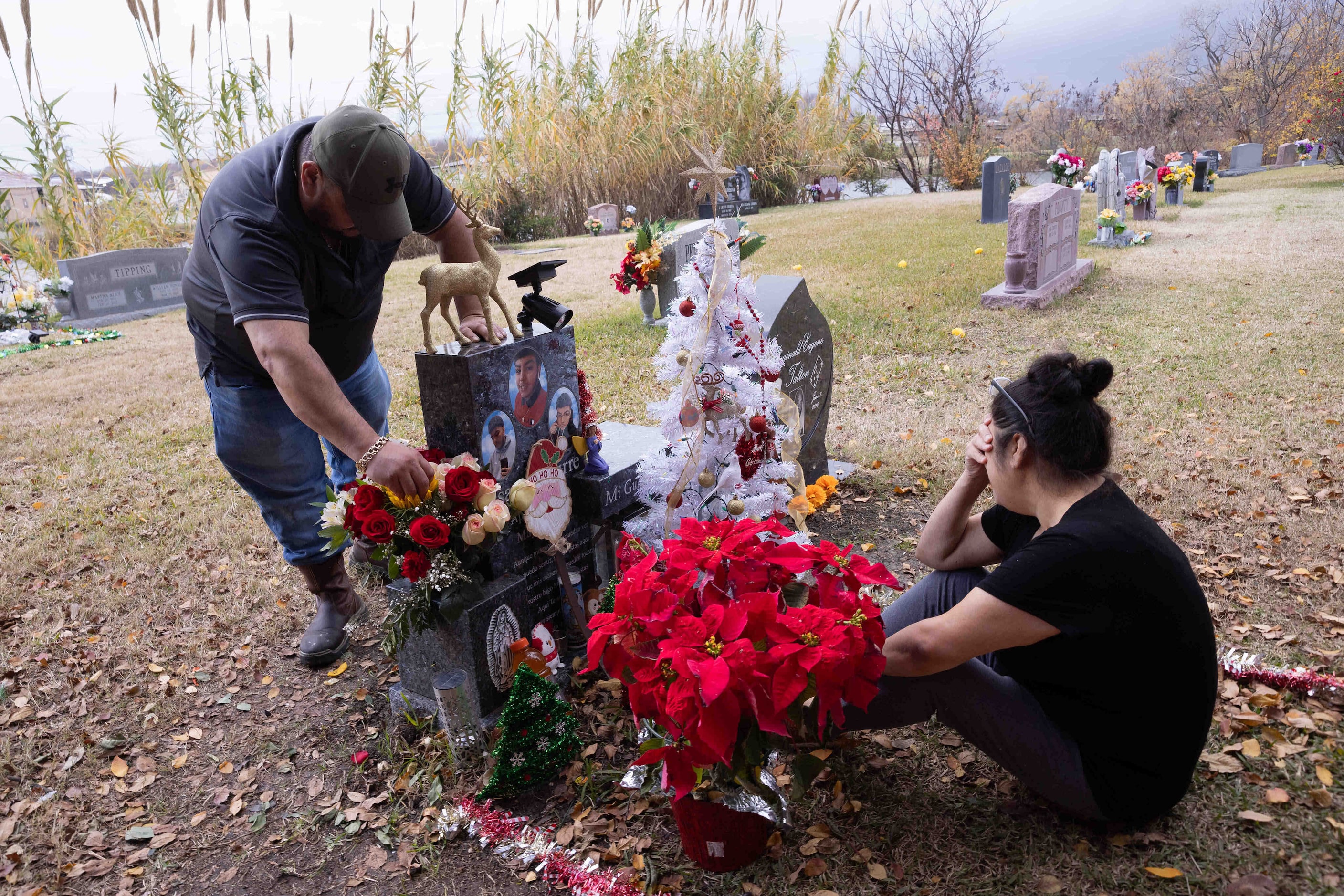 Benito Aguirre adjusts the Christmas decorations as Ana Aguirre holds her face in her hand...