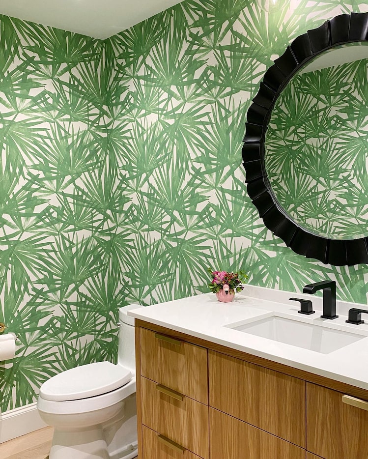 Green palm wallpaper in bathroom with wood vanity