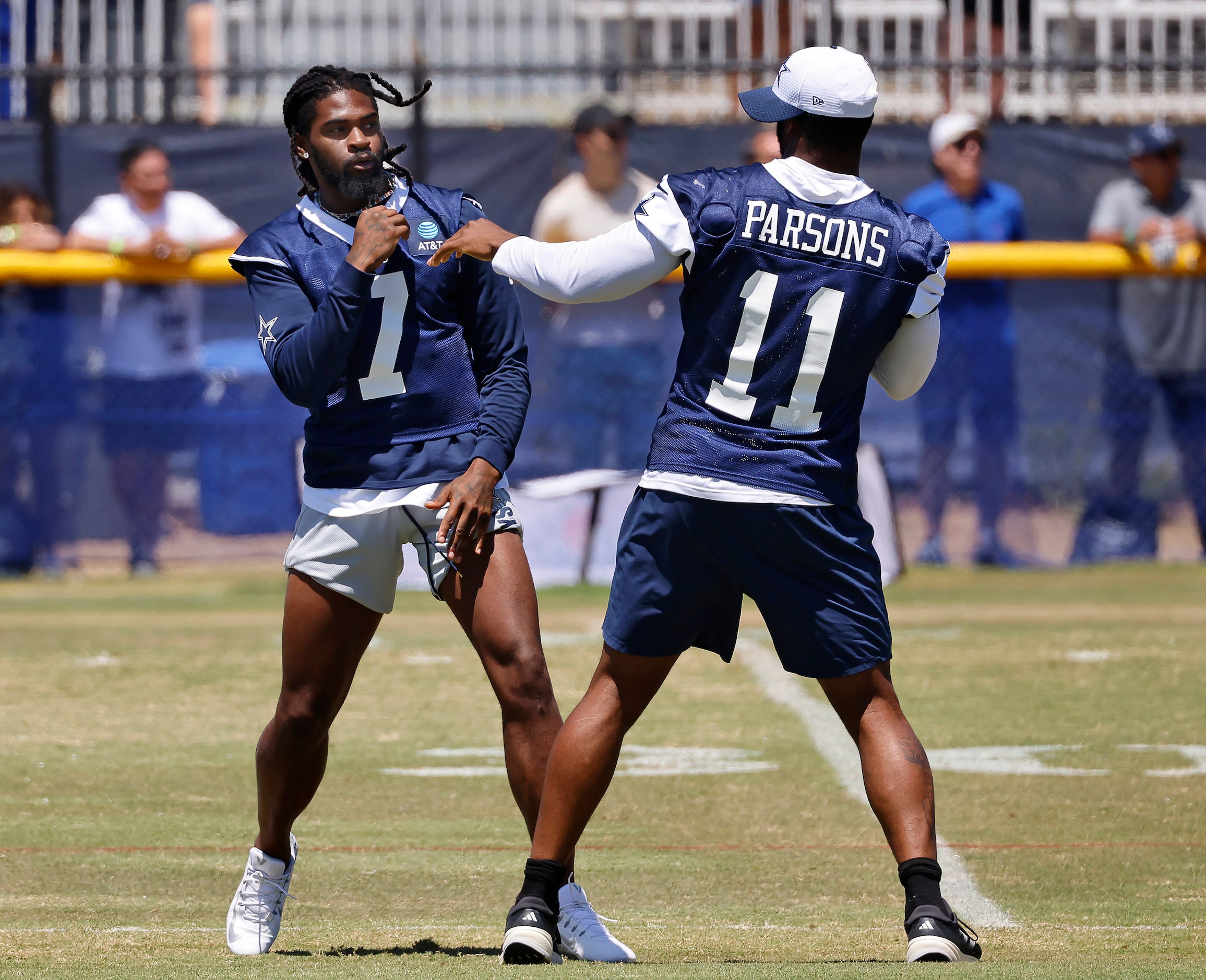 Dallas Cowboys cornerback Trevon Diggs (7) and linebacker Micah Parsons (11) playfully spar...