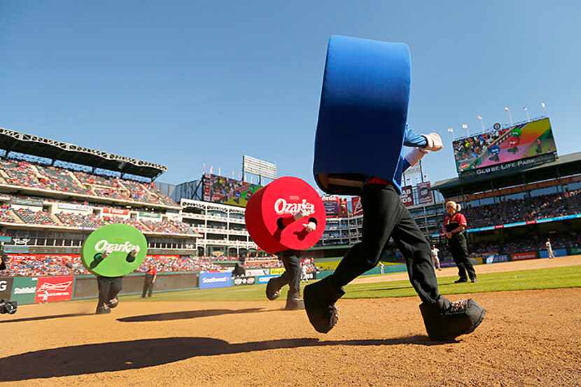  The dots in the Ozarka Dot Race race down the third base line between innings of the Texas...