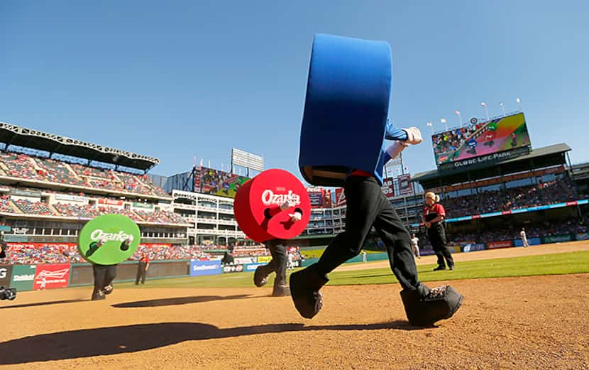  The dots in the Ozarka Dot Race race down the third base line between innings of the Texas...