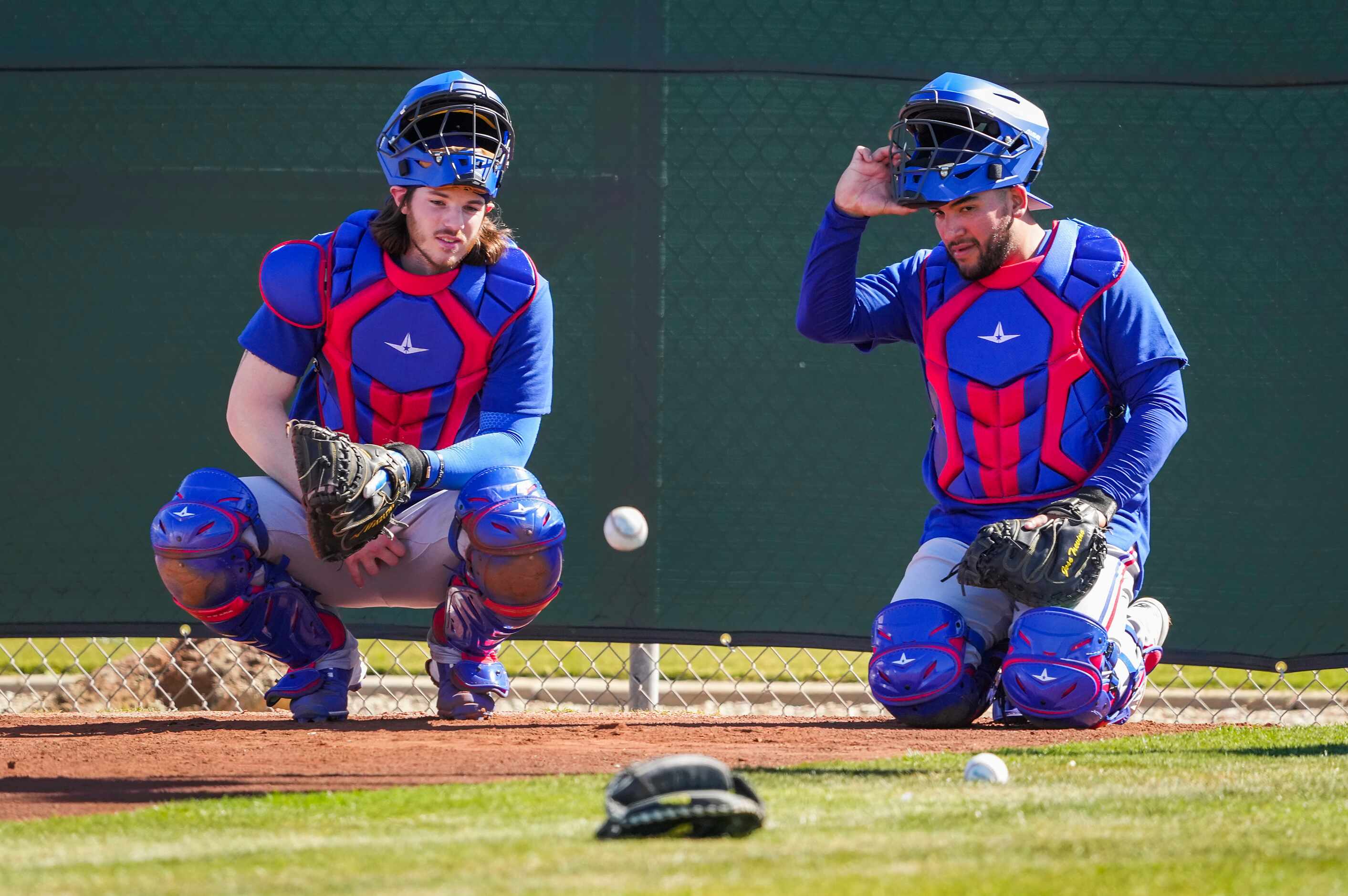 Texas Rangers catchers Jonah Heim (left) and Jose Trevino wait their turn in a defensive...