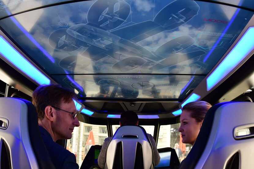 Visitors sit inside the Bell Nexus concept vehicle at the Uber Elevate Summit in Washington,...