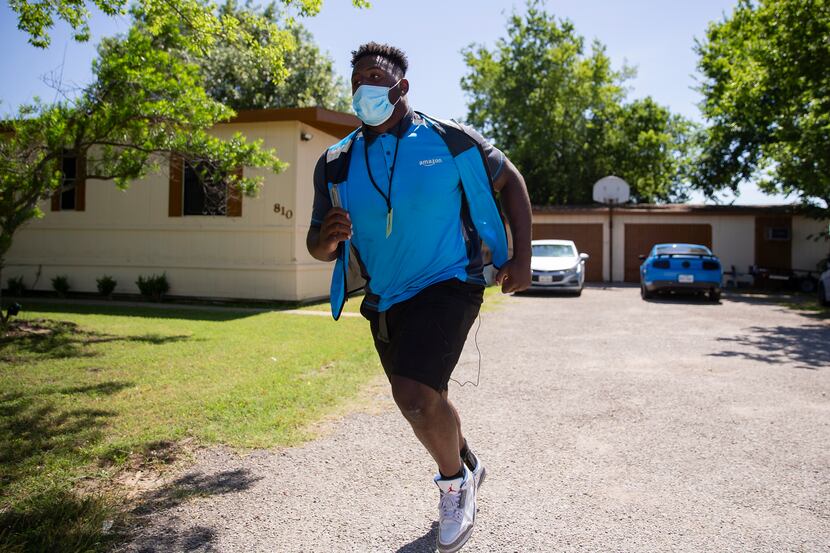 Mike Williams, a SMU defensive tackle, rushes back to his van after making deliveries while...