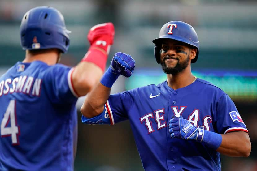 Texas Rangers' Leody Taveras, right, is greeted near home plate by Robbie Grossman after...