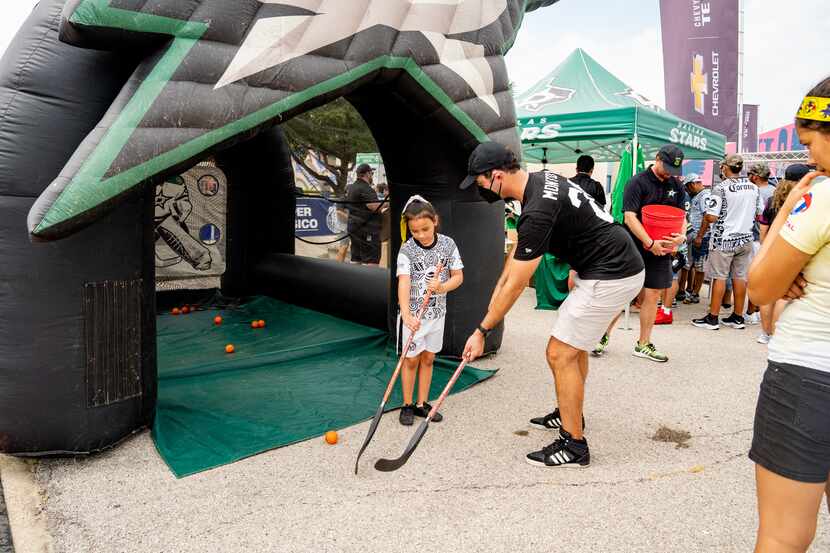 Al Montoya le enseña a una joven fan a usar el bastón de hockey.