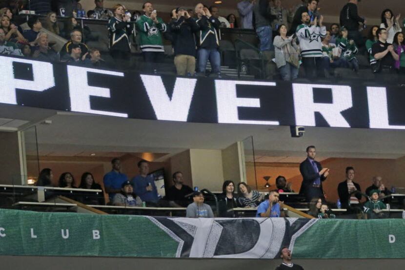 Dallas Stars fans applaud player Rich Peverley (standing below the 'R') during a...