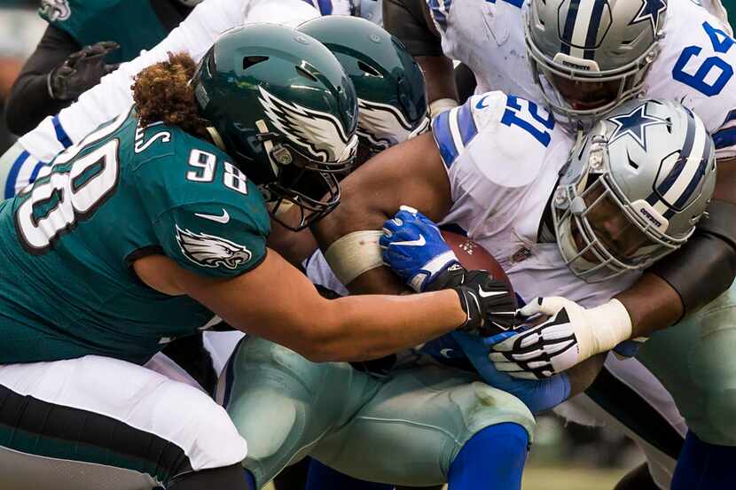 Dallas Cowboys running back Ezekiel Elliott (21) is wrapped up by Philadelphia Eagles...