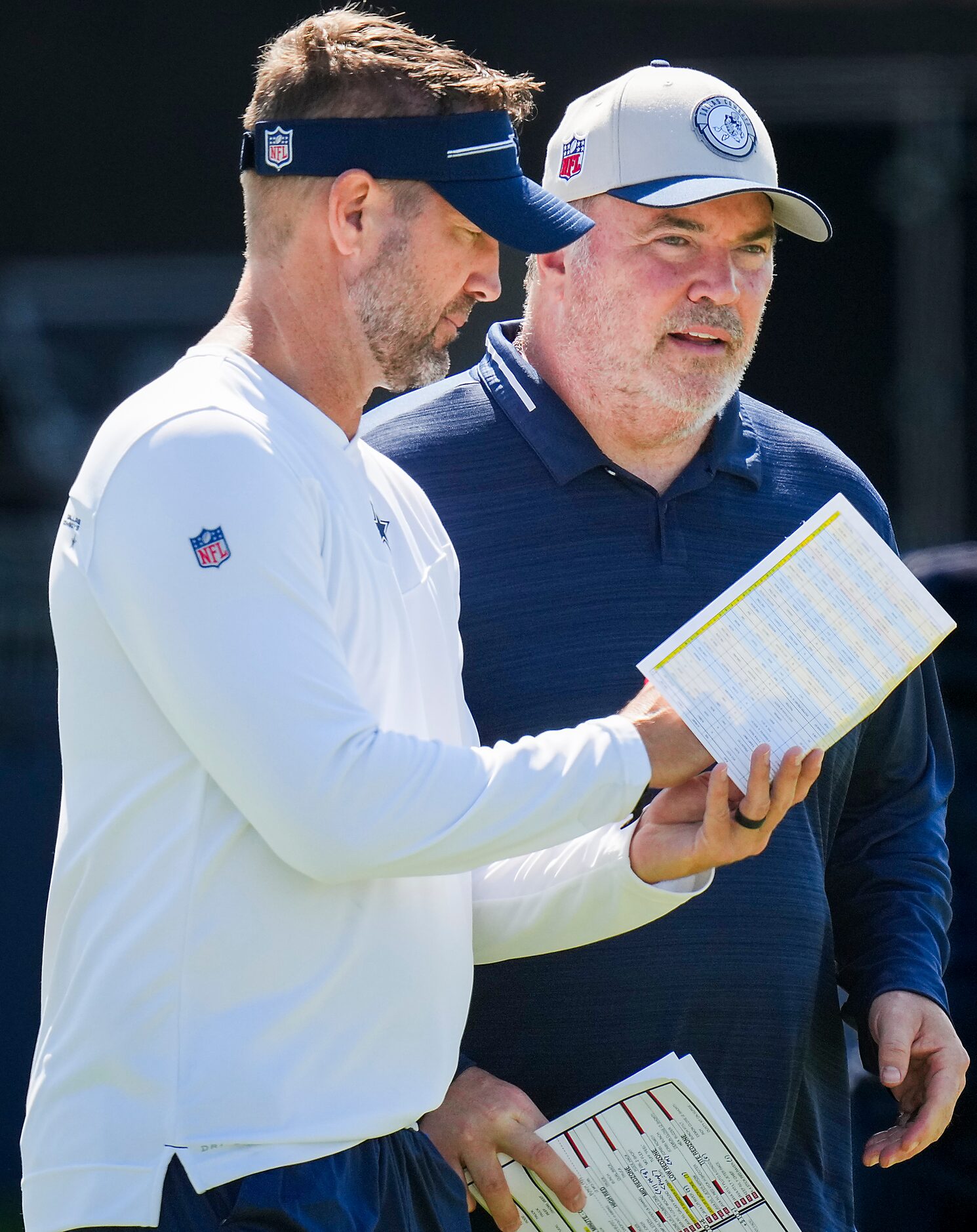 Dallas Cowboys head coach Mike McCarthy (right) talks with offensive coordinator Brian...