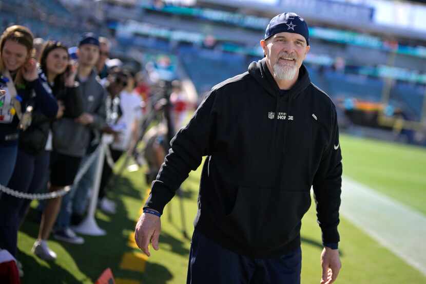 Dallas Cowboys defensive coordinator Dan Quinn walks along the sideline after talking with...