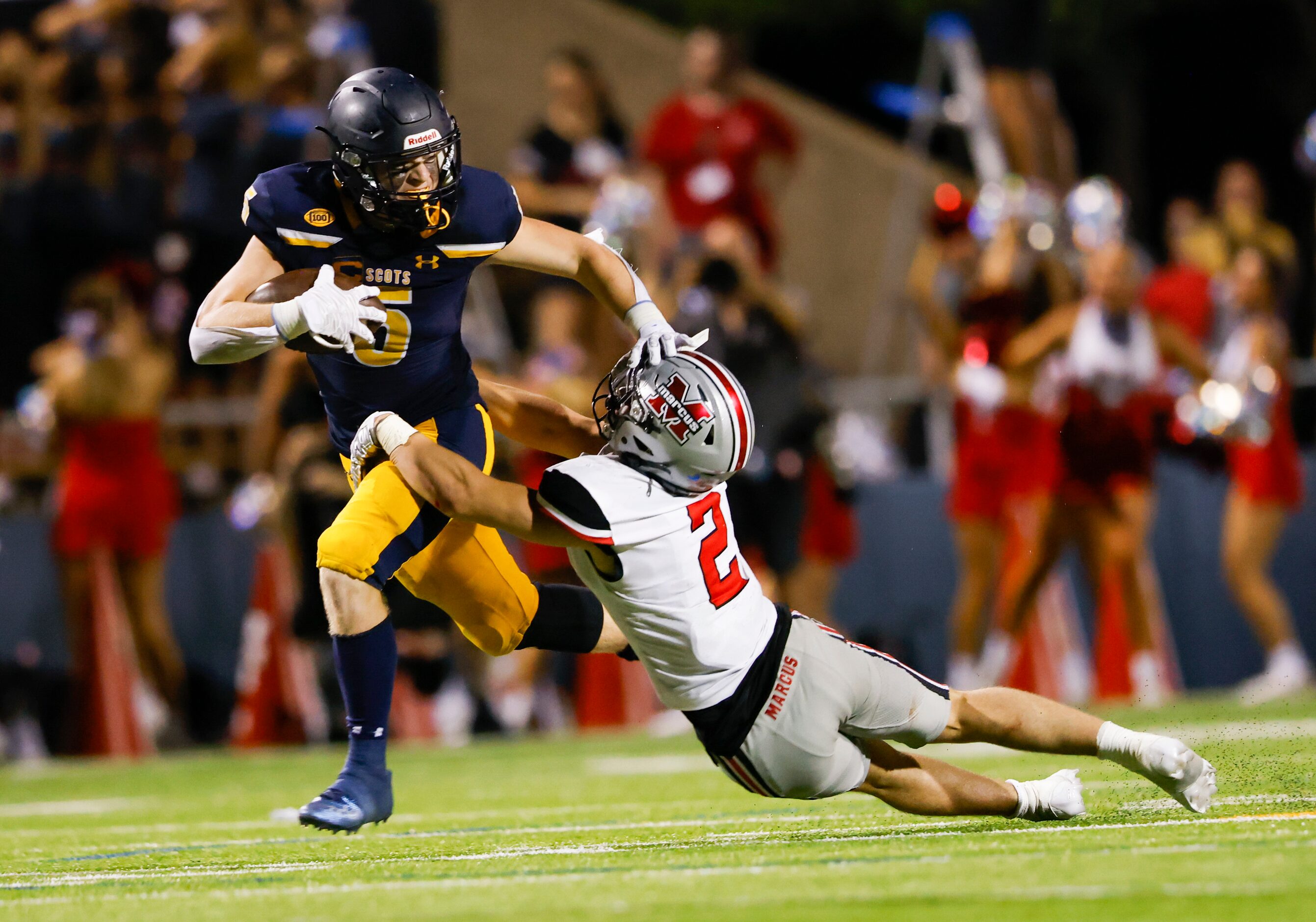 Highland Park running back Jay Cox (5) evades Flower Mound Marcus’ Jake Ballard (2) during a...