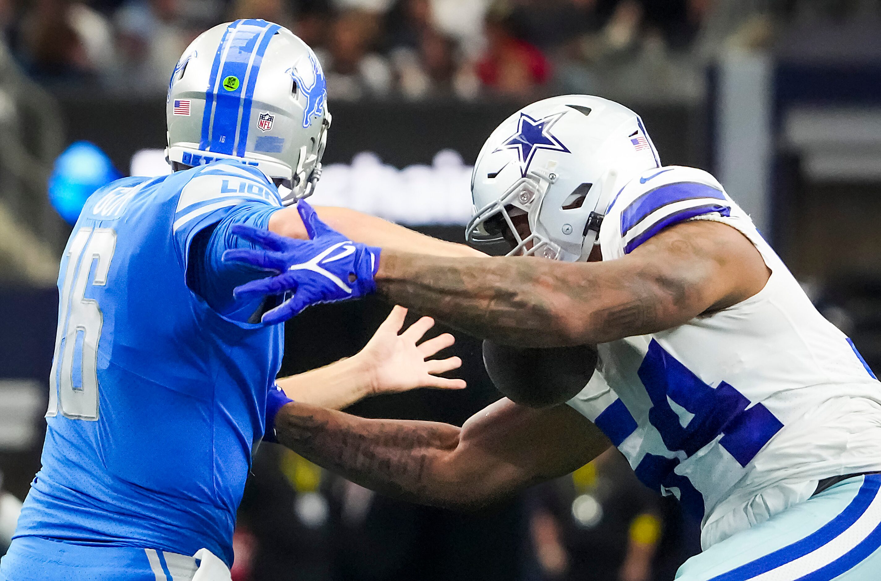 Dallas Cowboys defensive end Sam Williams (54) stips the ball from Detroit Lions quarterback...