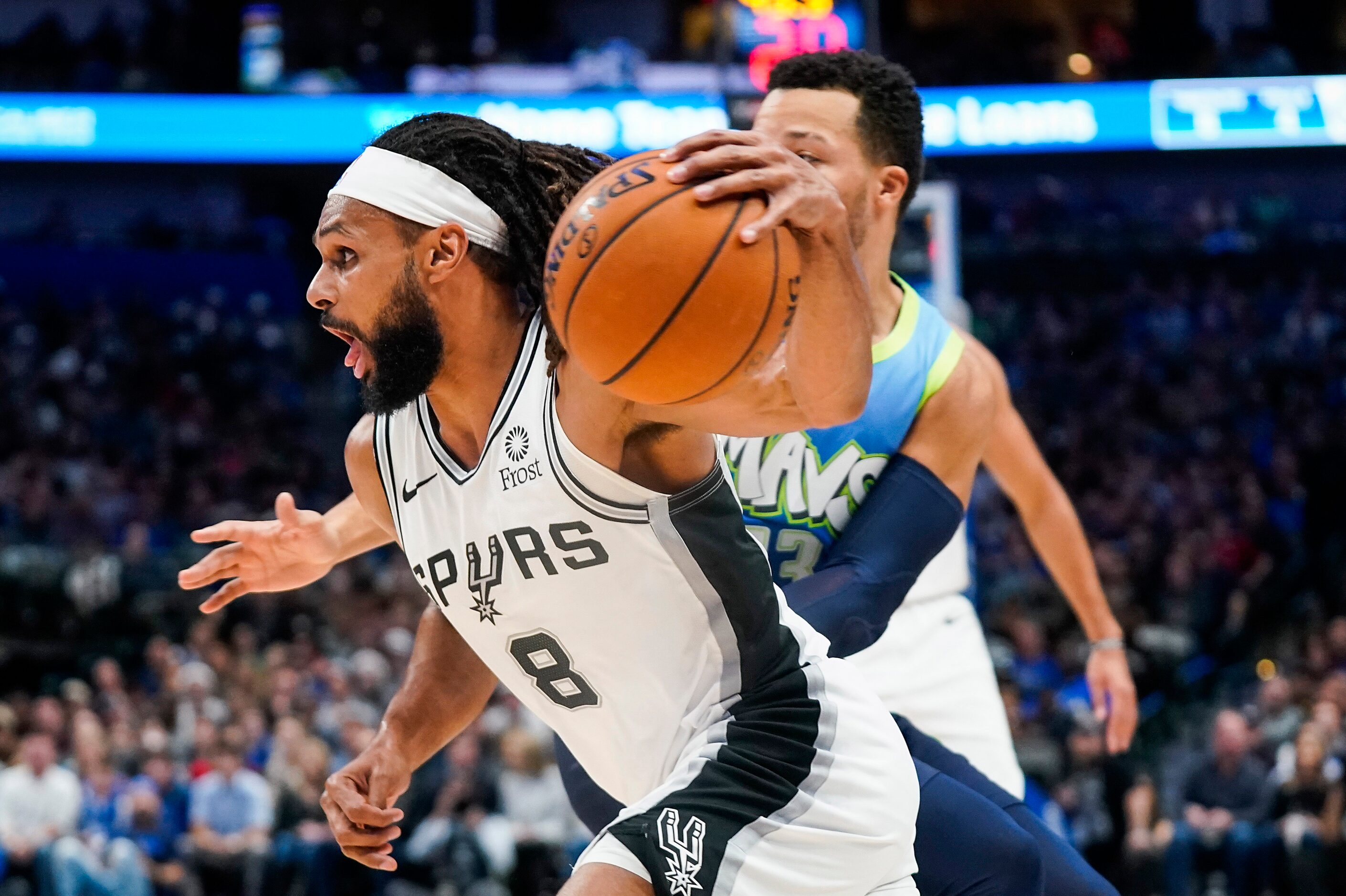 San Antonio Spurs guard Patty Mills (8) drives past Dallas Mavericks guard Jalen Brunson...