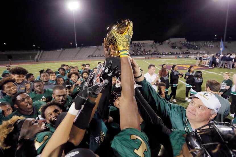 TXHSFB Longview head coach John King, right, celebrates a 75-43 win over Jesuit after a high...