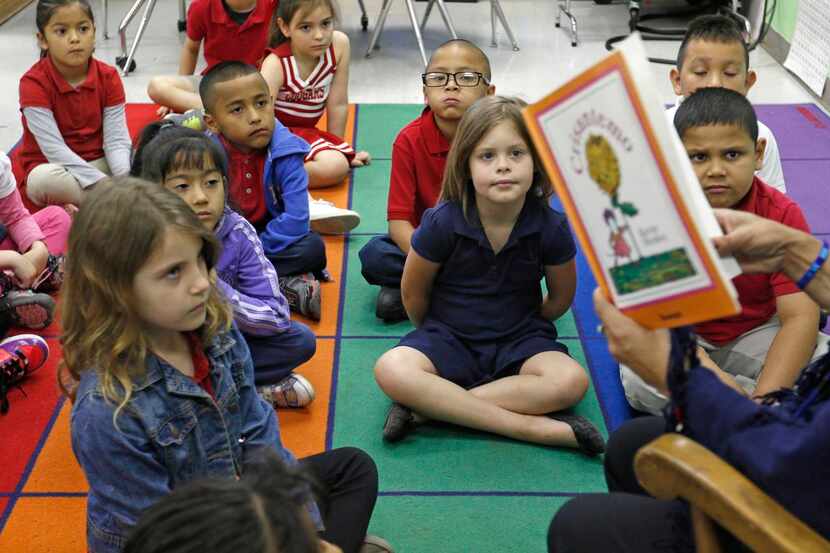 
First-grade students in Cruz Vargas' dual-language class listen to her read a book in...