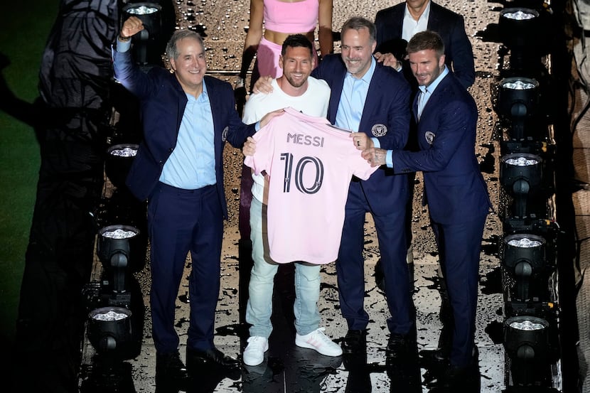 Lionel Messi stands with owners Jorge Mas, left, Jose Mas and David Beckham after he was...