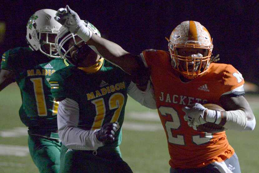 Mineola’s Trevion Sneed (23) stiff arms Madison’s Jeremiah Horn on his way to a touchdown in...