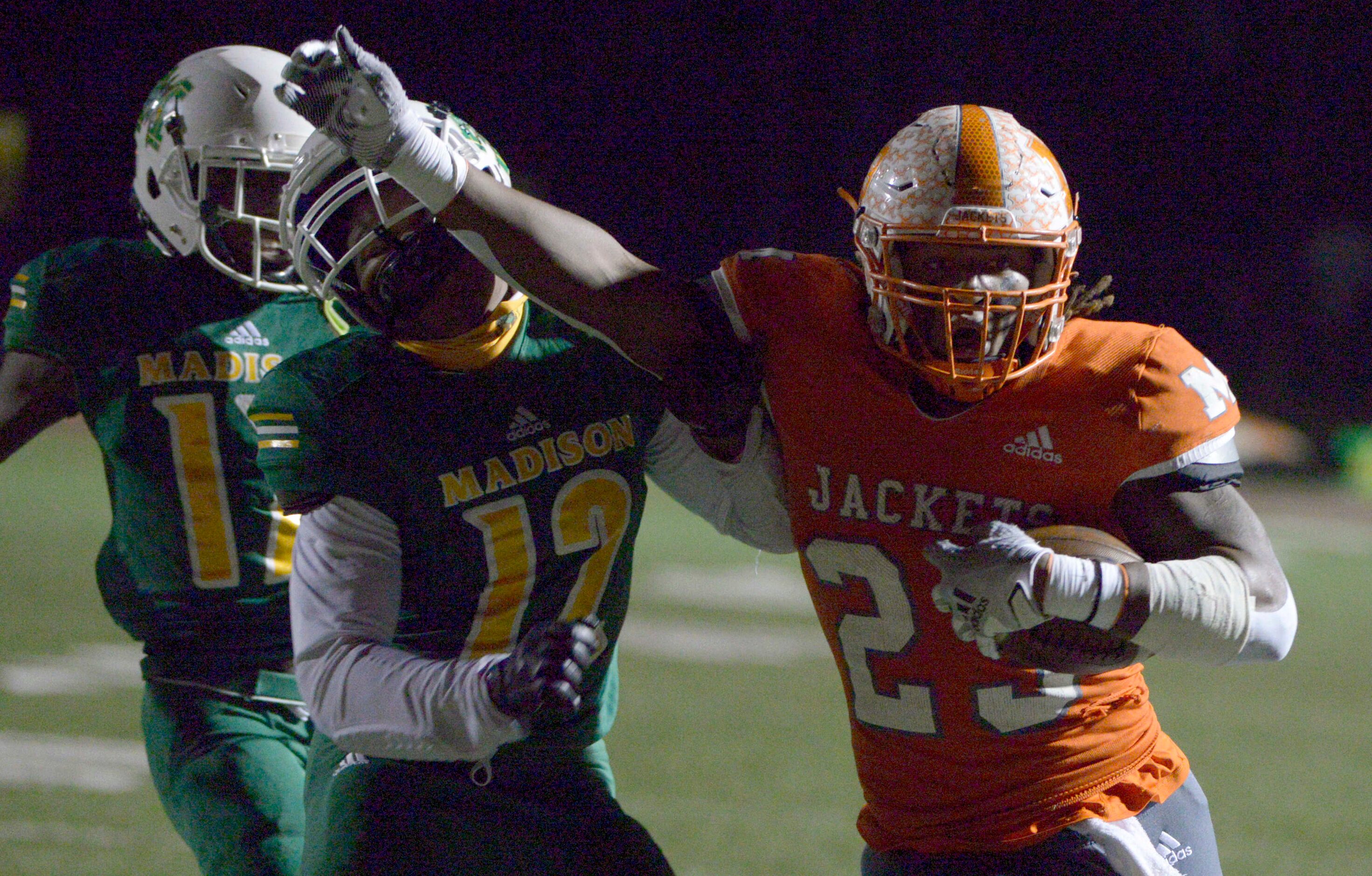 Mineola’s Trevion Sneed (23) stiff arms Madison’s Jeremiah Horn on his way to a touchdown in...