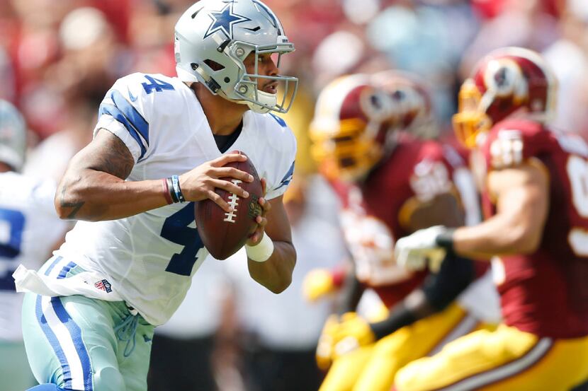 Dallas Cowboys quarterback Dak Prescott (4) rolls out of the pocket in a game against the...