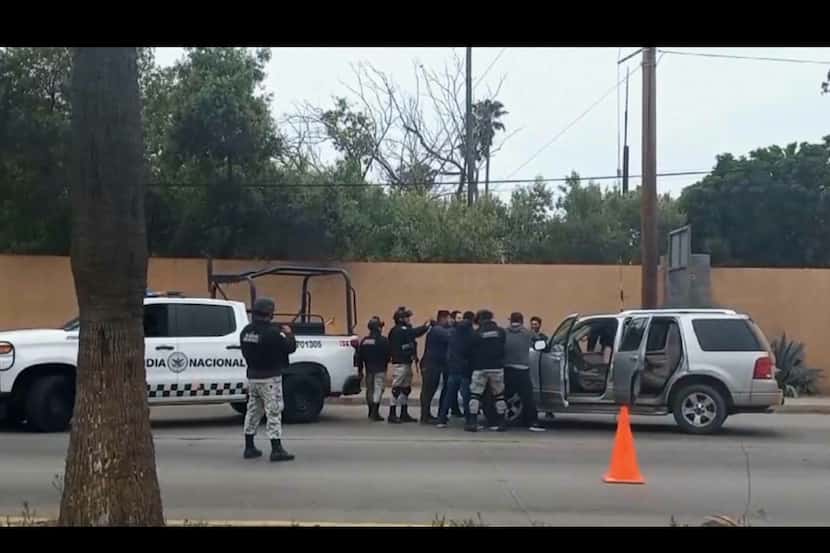 En esta imagen tomada de un video, fuerzas de seguridad mexicanas registran a hombres en un...