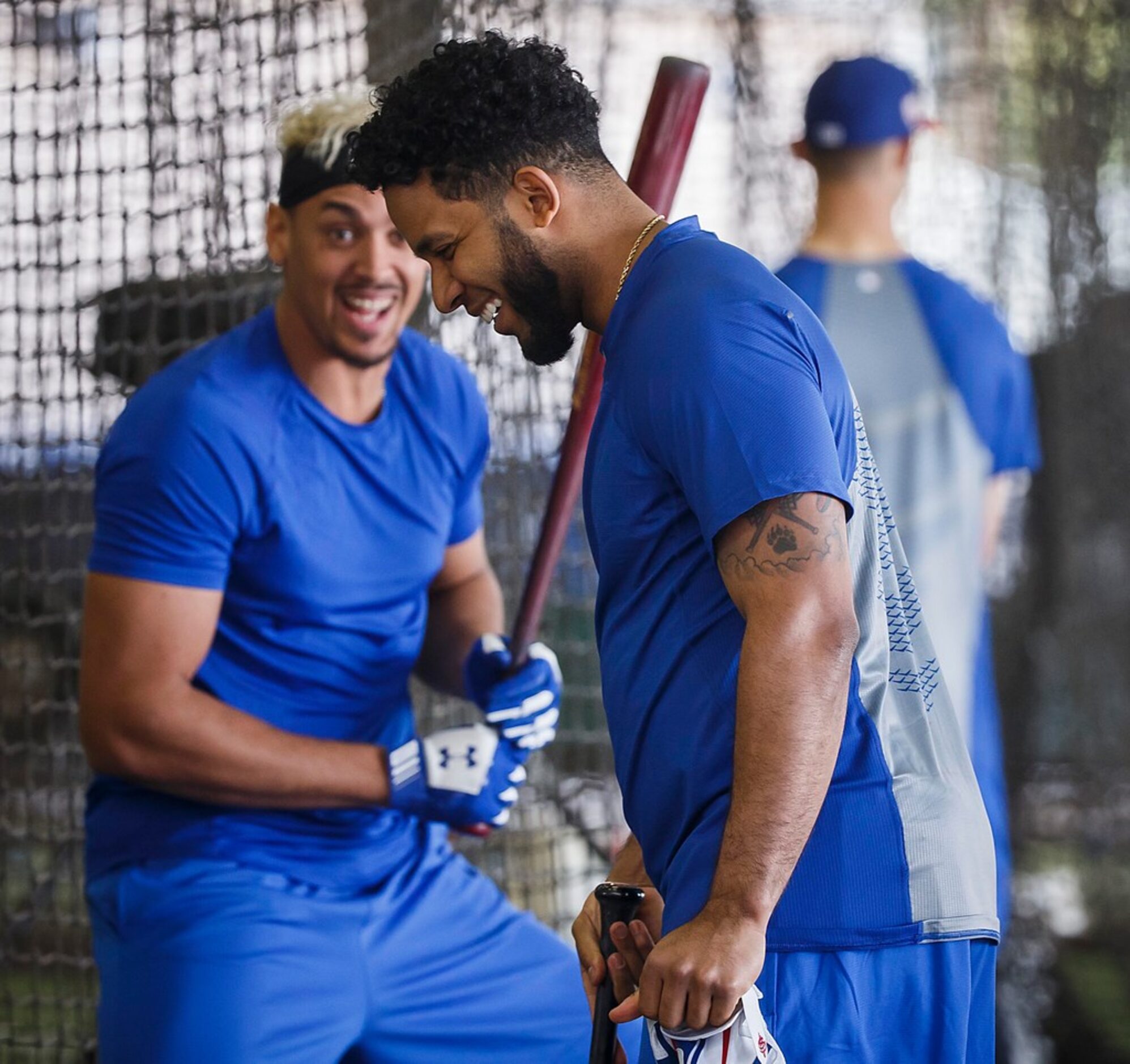 Texas Rangers shortstop Elvis Andrus laughs with infielder Ronald Guzman in the batting...