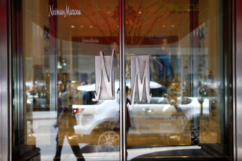 A pedestrian is reflected in the door of Neiman Marcus in downtown Dallas, Tuesday, March...