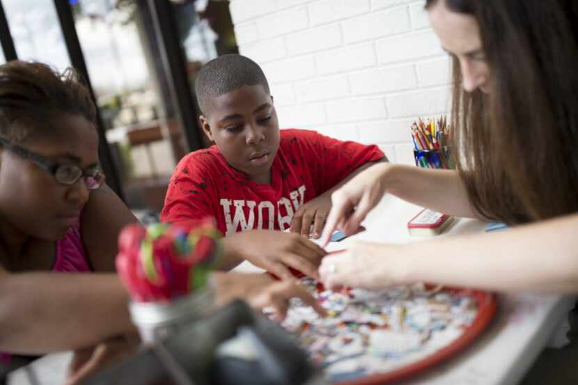 Kendrick Linnear (center), 11, of Dallas participates in a workshop led by artist Lisa...
