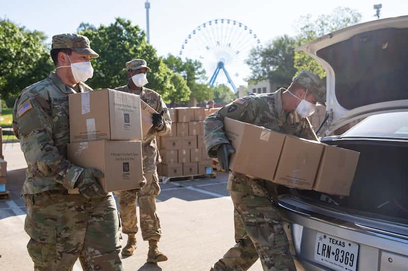 Members of the Texas National Guard help the North Texas Food Bank to distribute free food...
